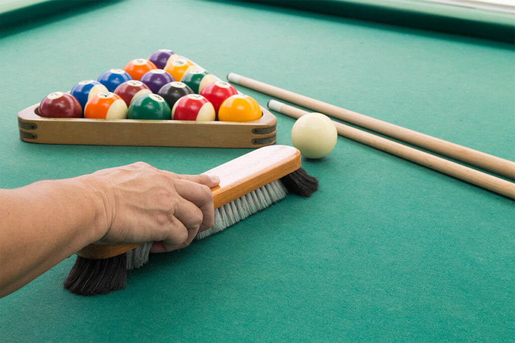 Hand brushing snooker pool billards table with balls and cue